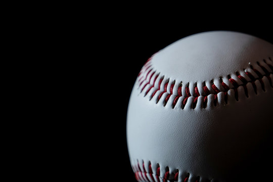 A white baseball with dark background