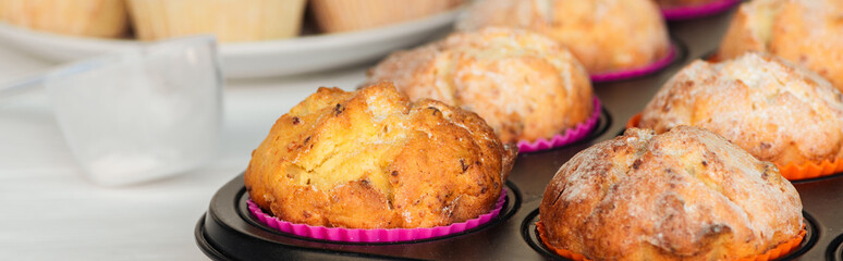 panoramic shot of delicious muffins in cupcake tray