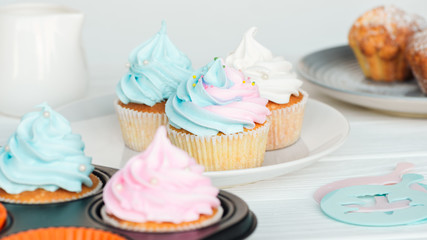 delicious cupcakes decorated with colorful frosting on plate isolated on grey