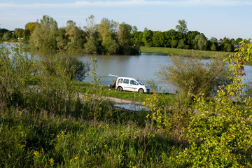 White car on the bank of the lake