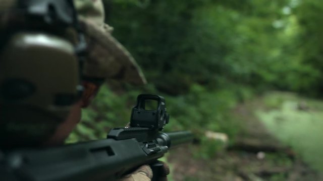 The soldier aims at the target. Fully equipped soldier.