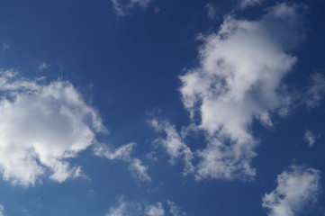  White clouds floating across a clear blue sky.