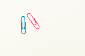blue and pink paper clips on white background. - top view.
