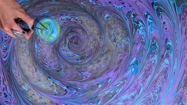 Artist creates absractive ebru design with orange, pink and white paints