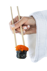 Japanese sushi roll with tobiko caviar on sticks in female hand isolated on white background. Healthy diet.