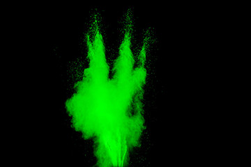 Abstract green powder explosion on  black background. Abstract green dust splattered on black background. Freeze motion of green powder splash.