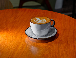 Cup of cappuccino pn brown color table