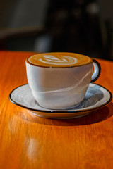 Vertical image Cup of cappuccino pn brown color table shot with copyspace