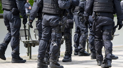 Bewaffnete Polizeieinheit in schwarzer Uniform auf Einsatz auf einer Demo