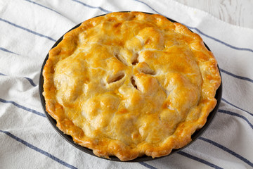 Homemade apple pie on cloth, side view.