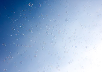 Soap bubbles fly in the blue sky