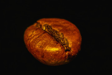 Coffee grain on black background magnified, closeup.