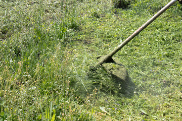mowing the grass with a mower.
