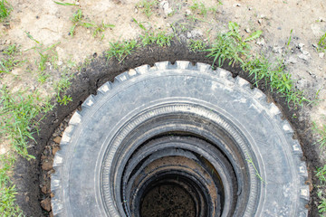Sewer pit with car tires.