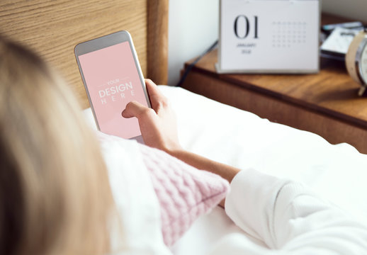 Person Using Smartphone on a Bed Mockup