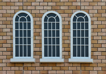 classical vintage design window on weathered red brick blocks wall background.
