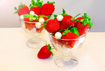 Strawberries in glass bowl standing on the table. Selective focus.