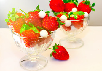 Strawberries in glass bowl standing on the table. Selective focus.