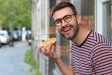 Cheerful European man enjoying dessert outdoors 