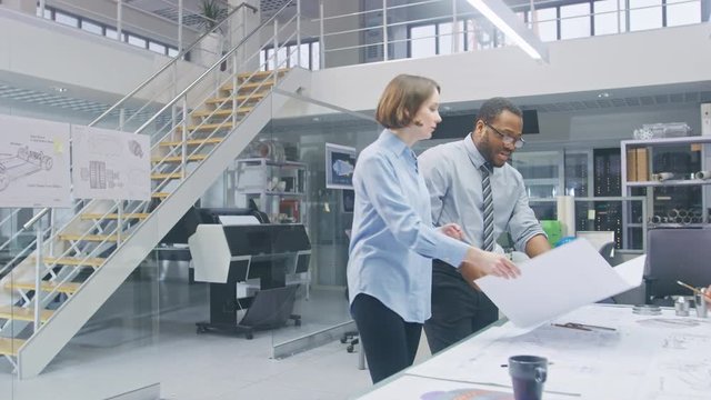 In the Industrial Engineering Facility: Two Architects Print Drafts of Industrial Engine Prototype and Bring it to Chief Engineer, Start Discussion and Analysis Using Conference Table. 