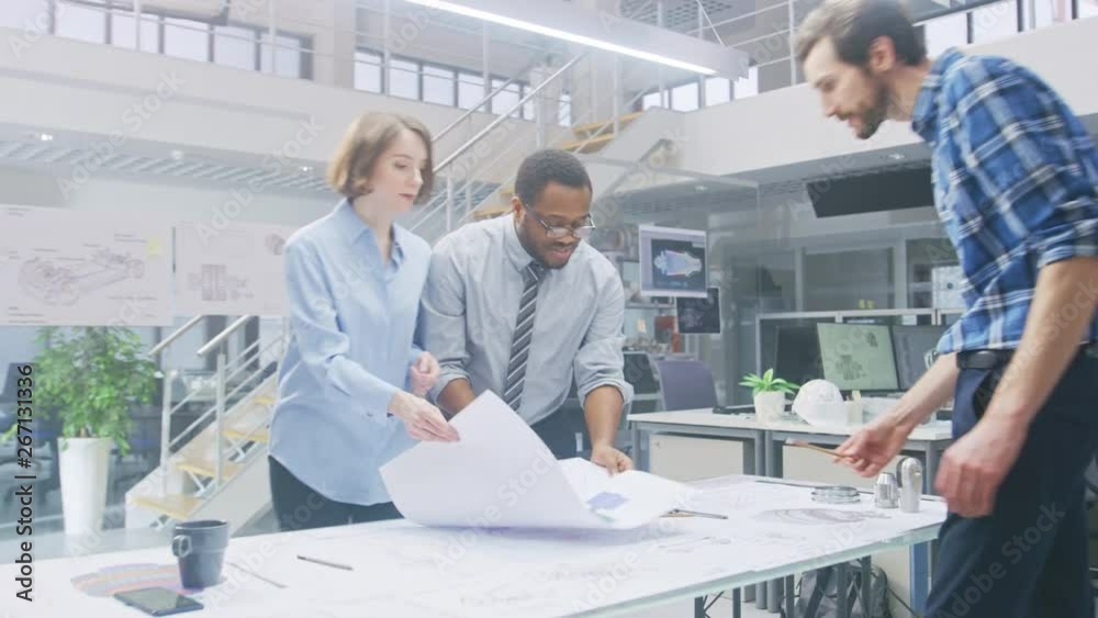 Poster In the Industrial Engineering Facility: Two Architects Print Drafts of Industrial Engine Prototype and Bring it to Chief Engineer, Start Discussion and Analysis Using Conference Table. 
