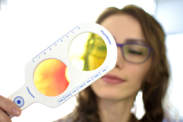 pretty young woman optometrist ophthalmologist optician performs a color blindness test, low depth...