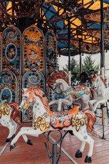 Multi-colored children's carousel with horses marry-go-round at the summer fair. Vertical image.