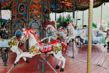 Multi-colored children's carousel with horses marry-go-round at the summer fair. Horizontal image.