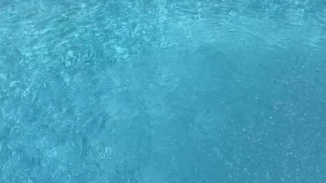 The blue of the water jet flow poured into the pool