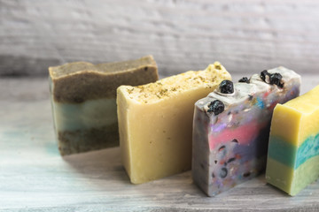 beautiful handmade colorful natural soaps on white wooden background