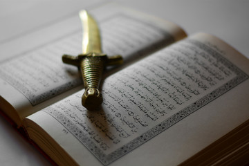 an ancient knife on the holy book of the Koran