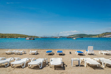 Fototapeta na wymiar Beautiful exotic beach with deck chairs in Bodrum, Turkey