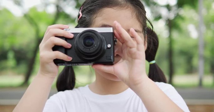 Asian little girl photography nature with camera. concept of technology, take photo and life experience. 4K resolution and slow motion.