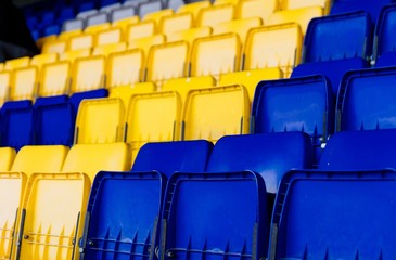 Naklejka premium Yellow and blue plastic empty stadium seats.