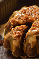 Sliced chocolate cake with caramel on a wooden background