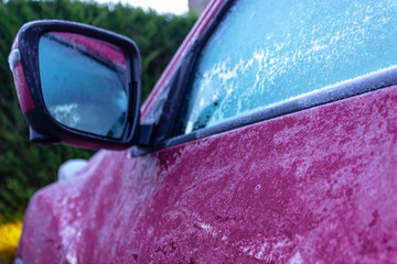 Purple car covered in frost on a very cold winter morning