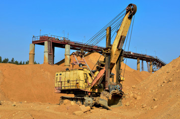 Fototapeta na wymiar Large excavator in a quarry for the extraction of sand, gravel, rubble, quartz and other minerals