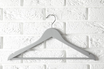 Empty clothes hanger on brick wall. Wardrobe accessory