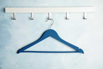 Rack with empty clothes hanger on color wall. Wardrobe accessory