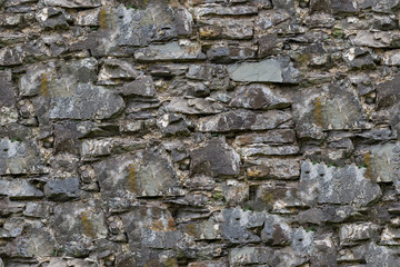 Seamless texture of high resolution of the old masonry of the wall from a block of gray granite, places covered with moss and mud. Useful for designer, architect and game developer