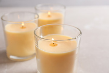 Three burning candles in glasses on table