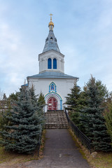 Fototapeta na wymiar Intercession Church in the village of Bushiki Glubokoe district a landmark of Belarus. The 18th century village Church is located on a hill surrounded by trees. Orthodox church.