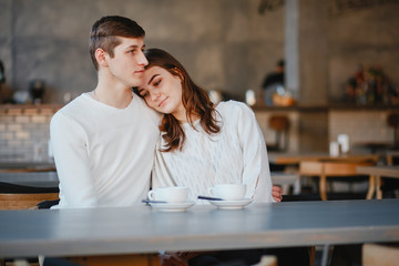 Pretty couple sitting in a cafe. Man and woman drinking a tea