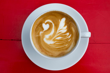 Cappuccino with stunning latte-art on a red background