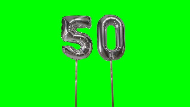 Number 50 fifty years birthday anniversary silver balloon floating on green screen