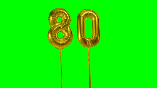 Number 80 eighty years birthday anniversary gold balloon floating on green screen