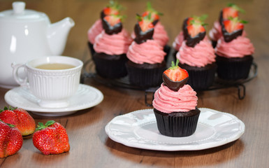 Fresh homemade chocolate cupcakes with buttercream and strawberries