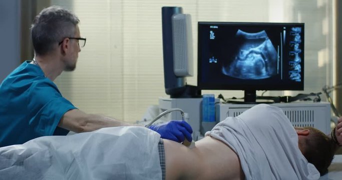 Doctor examining man with ultrasound
