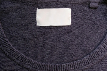 Clothing White label inside of blue sweater. White label on a blue sweater.