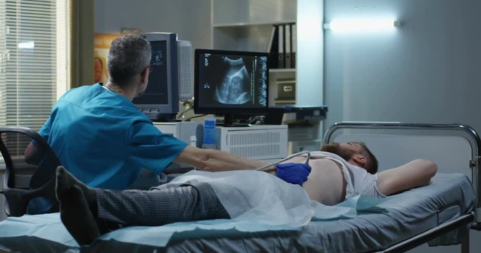 Doctor examining man with ultrasound